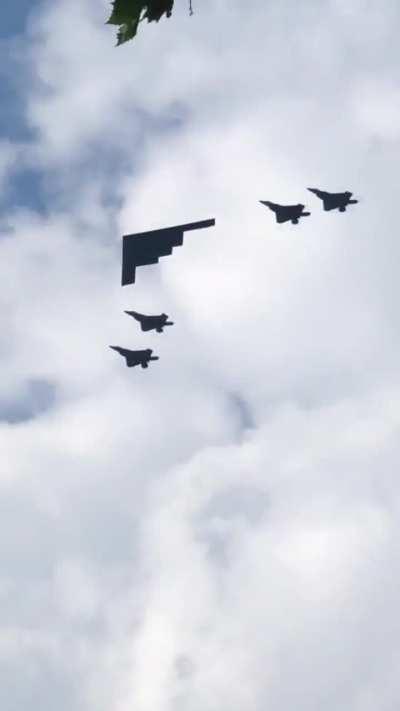 A B-2 being escorted by F-22s.