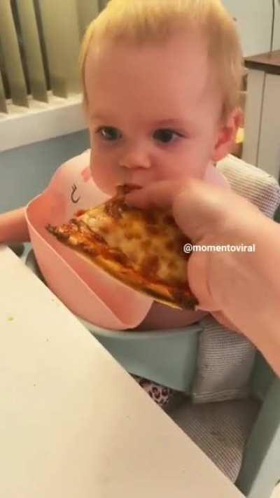 Baby's first bite of pizza