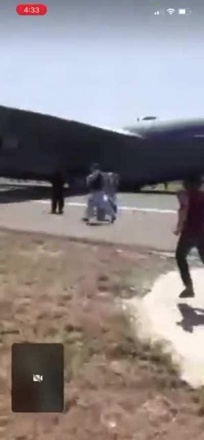 Apache doing crowd control to clear the runway for a C-17 military transport aircraft at Hamid Karzai International Airport in Kabul, as hundreds of people are trying to get on flights out of Afghanistan.