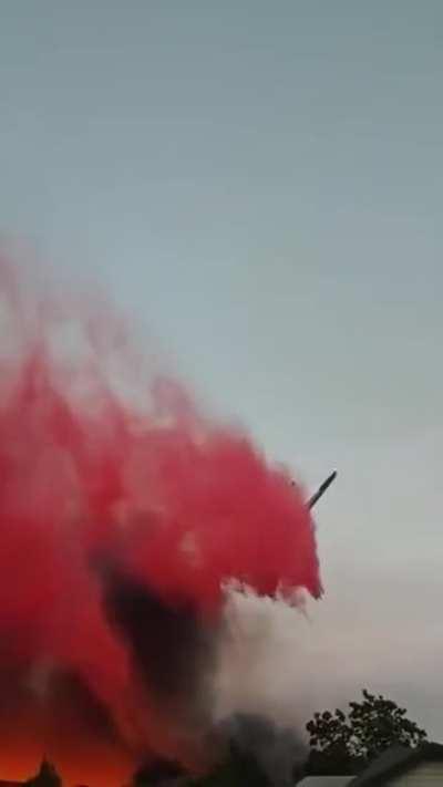 [Video] An aerial firefighting aircraft emerges from thick smoke to make a slurry drop on a neighborhood - videographer unknown