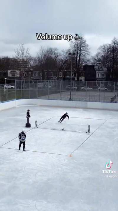 Two Canadians dudes playing tennis on ice.