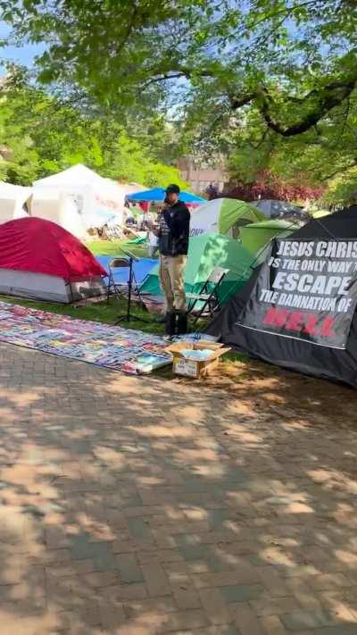 MC uses megaphone to talk over Gaza protestors at a university.