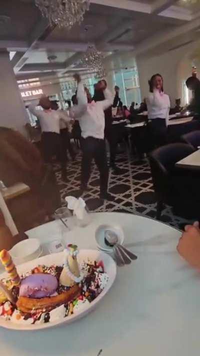 No idea about the context but I do wonder if these waiters schedule dance practice on company time.