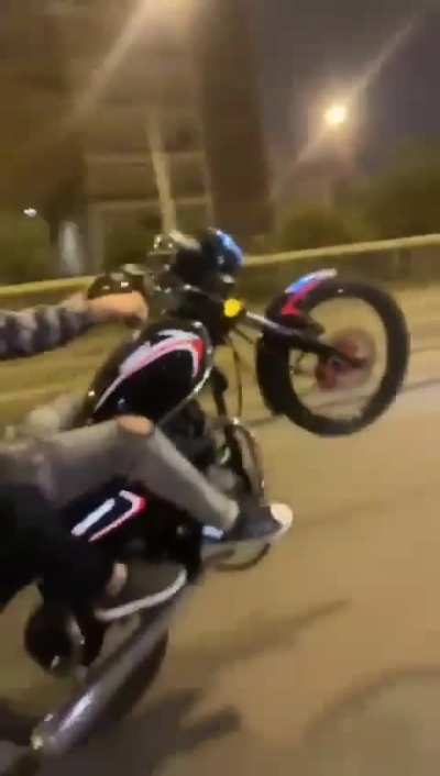 Being taken out by a pole while doing a wheely, the girl is ok