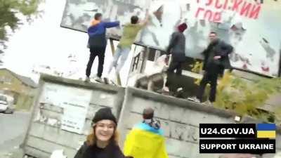 People tear the poster with the inscription 