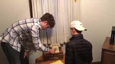 Two teenagers attempt to dial a phone number with a rotary phone