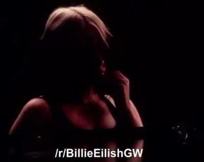 Billie Eilish taking her top of at a live show