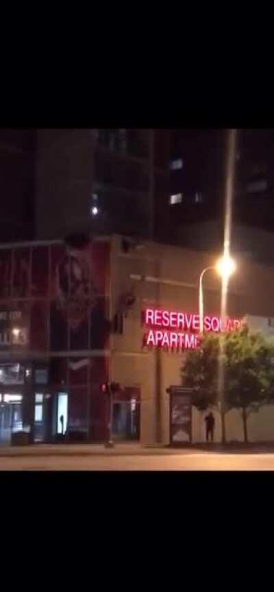 Man parachuting by the Reserve Square Apartments