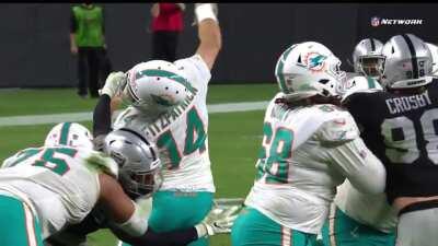 Miami Dolphins backup quarterback Ryan Fitzpatrick completes a no-look pass to Mack Hollins while a defender grabs his facemask