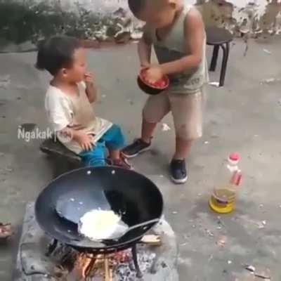 Young kid cooks for his little sister