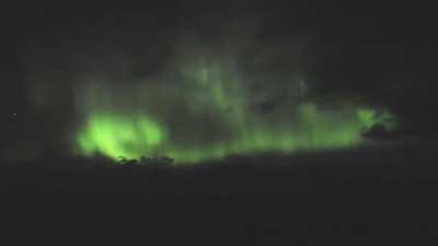 Pink meteor flies across northern lights