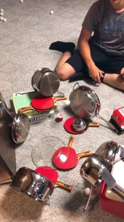 Bouncing a ping pong ball off pots and pans into a cup