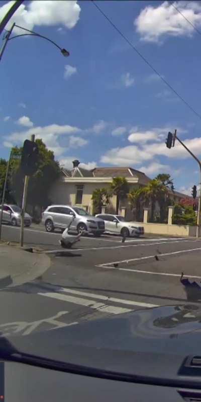 Motorcycle rider trys to beat the lights changing. 