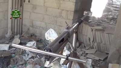 A rebel fighter from the Abu Dhar al-Ghafari Brigade shoots a homemade 'armor-piercing sniper' at a building in Irbeen, Syria (August 2013)