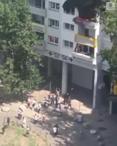 Two school boys falling from a fire into their rescuers arms. One rescuer broke an arm from the impact.