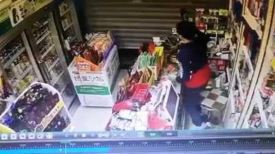Thief trying to sneak under shutter down but gets hit with a bottle