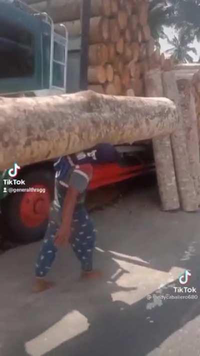 Filipino man casually lifts log