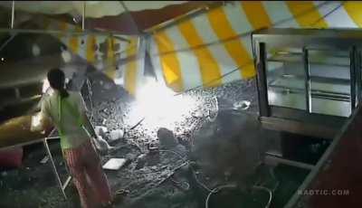 Truck takes out food stand.