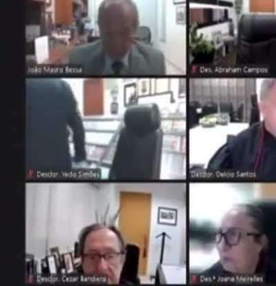 O desembargador Yedo Simões, do TJ/AM, comprou uma biblioteca falsa para servir de cenário nas sessões online. Ontem, a pseudo estante despencou durante uma sessão.