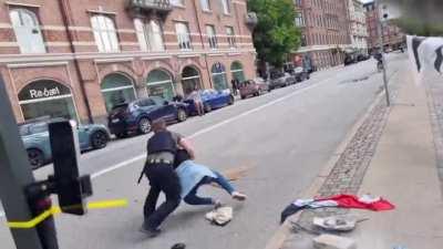 a momima tries to stop the quran burning in Denmark and gets tackled to the ground. 