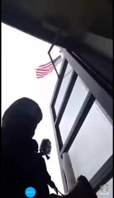 Man walks into police station, wearing a mask, and carrying an assault rifle.