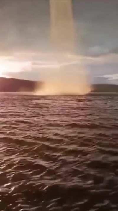 up-close to a curved water spout in the kama river in russia