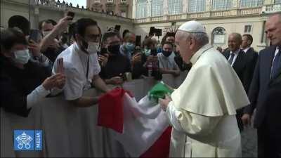 The Pope kisses the Lebanese flag.