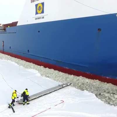 Harbor pilot boarding a ship in icy waters