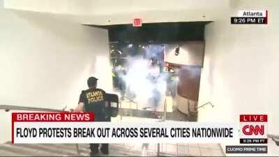 Firecracker thrown in the space between protesters and police at the CNN Center in Atlanta