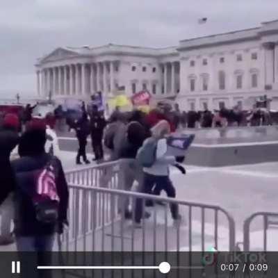 Police officer waving in the MAGA terrorists.. hurry hurry!!