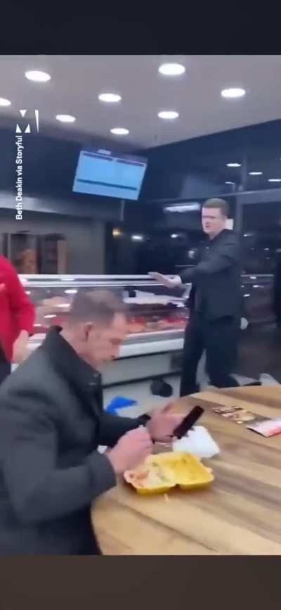 Ruckus in a kebab shop, man watches on eating his chips.. Dinner and a show