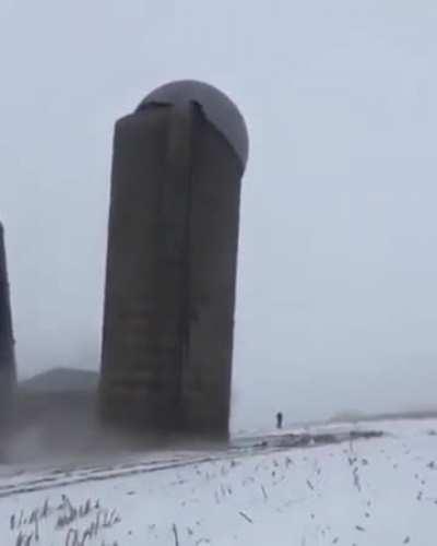 Silo gracefully falls to the ground during demolition.