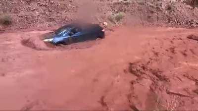 Family stuck from flashflood while dad records another vehicle floating down in flood with people still in it.