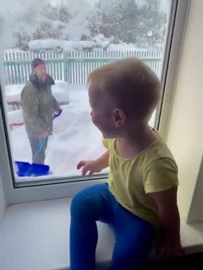 Toddler laughs hysterically while dad throws snow at the window!