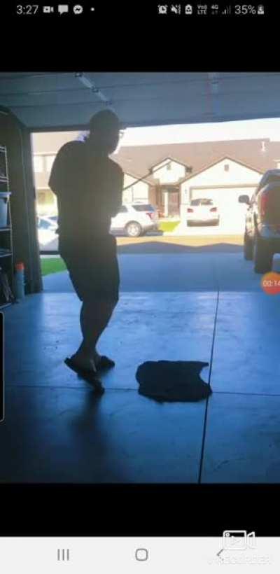 Practising your golf swing in the shed with a car parked accross the road