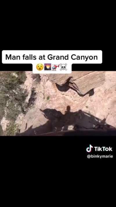 Guy falls after jumping over the guard rail at the Grand Canyon.