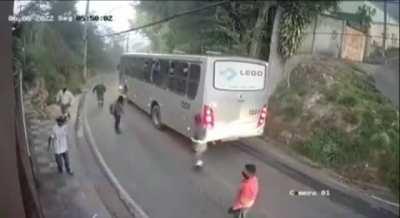 Guy assaults a girl in front of a passing bus