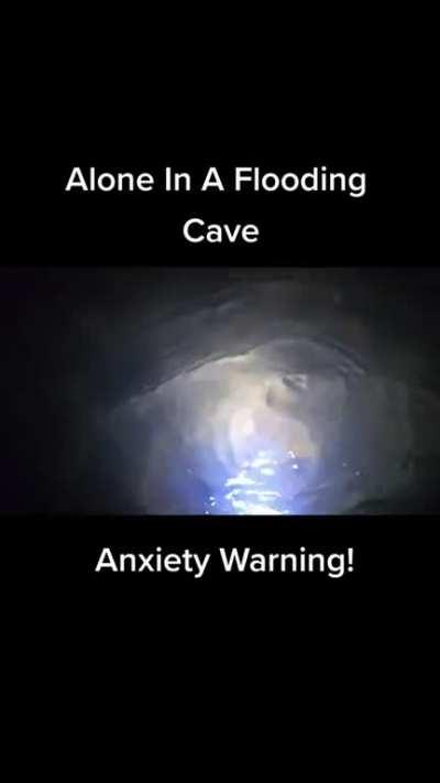 Man exploring cave when it begins to fill up with water.