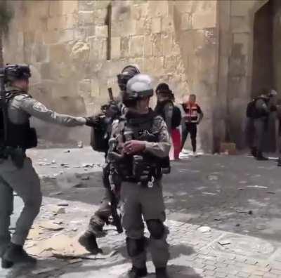 A journalist caught an Israeli soldier about to throw what looks like a smoke grenade at Medics and Journalists but he stopped when she caught him on camera.