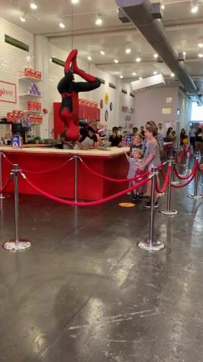 Big sister steps aside to let her little brother get ice cream from Spider Man.