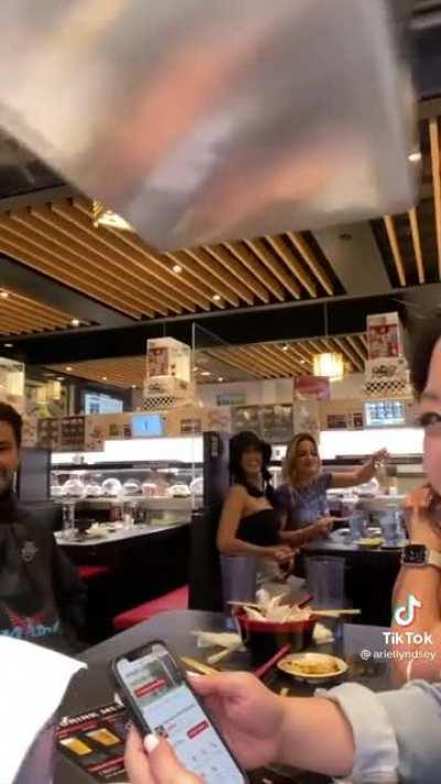 Putting Phone On Conveyor Belt At Sushi Restaurant