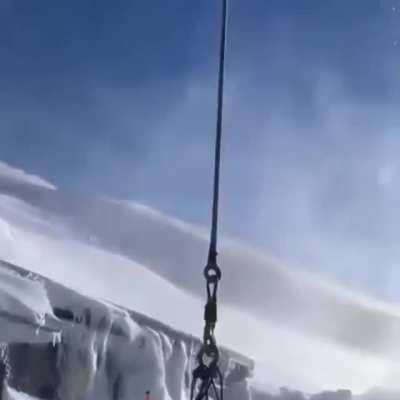 Helicopter picking up a month's worth of garbage from a hidden bunker in the mountains