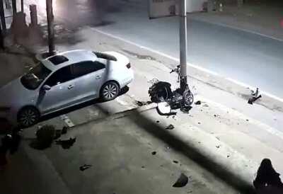 Helmetless lady on a scooter crashes into a light pole and somehow survives!