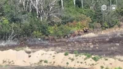 Two russian soldiers walking past a breached barbed wire barrier are hit by FPV of Madyars Birds, September 2025.