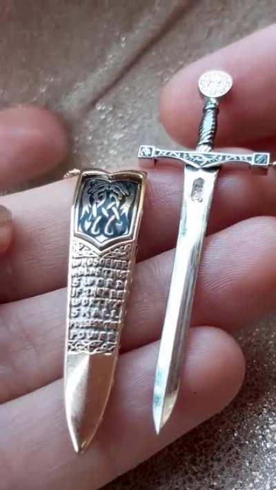 Excalibur sword necklace that can be unsheathed by a hidden button I designed.