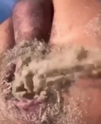 Sand dumping out of mans butthole at the beach