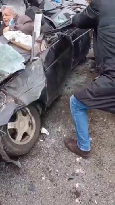 Ukrainians trying to rescue a man from his crushed car, after a Russian tank drove over it on purpose