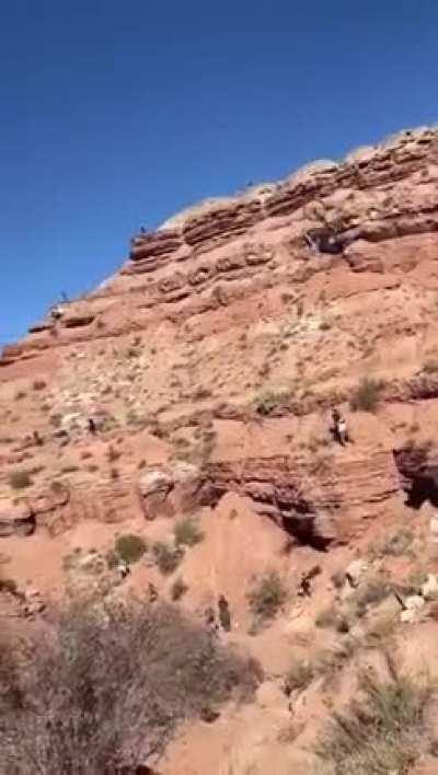 Even though he's on a bicycle, he's wearing a motorcycle helmet, for good reason.