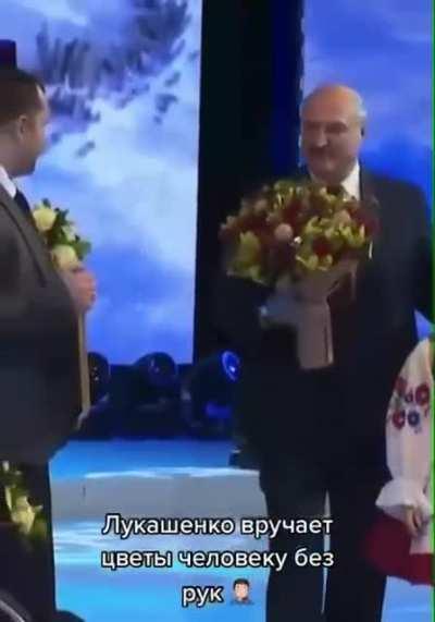 Belarusian Alexander Lukashenko handed a bouquet of flowers to a man without hands and patted him on the shoulder