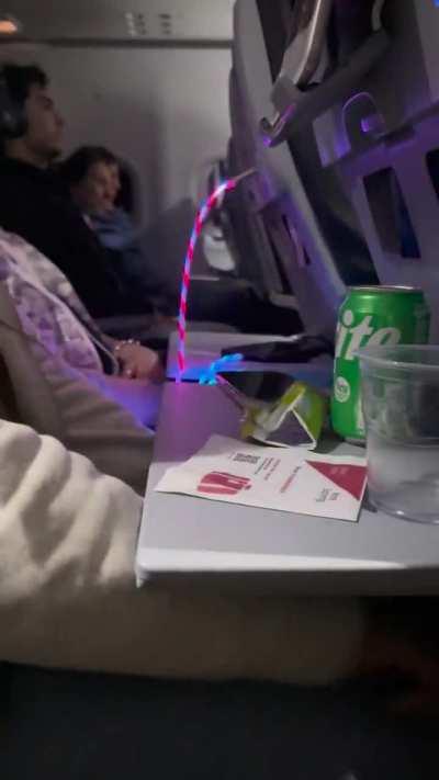 This woman’s charger in my row during a 6+ hour red eye flight